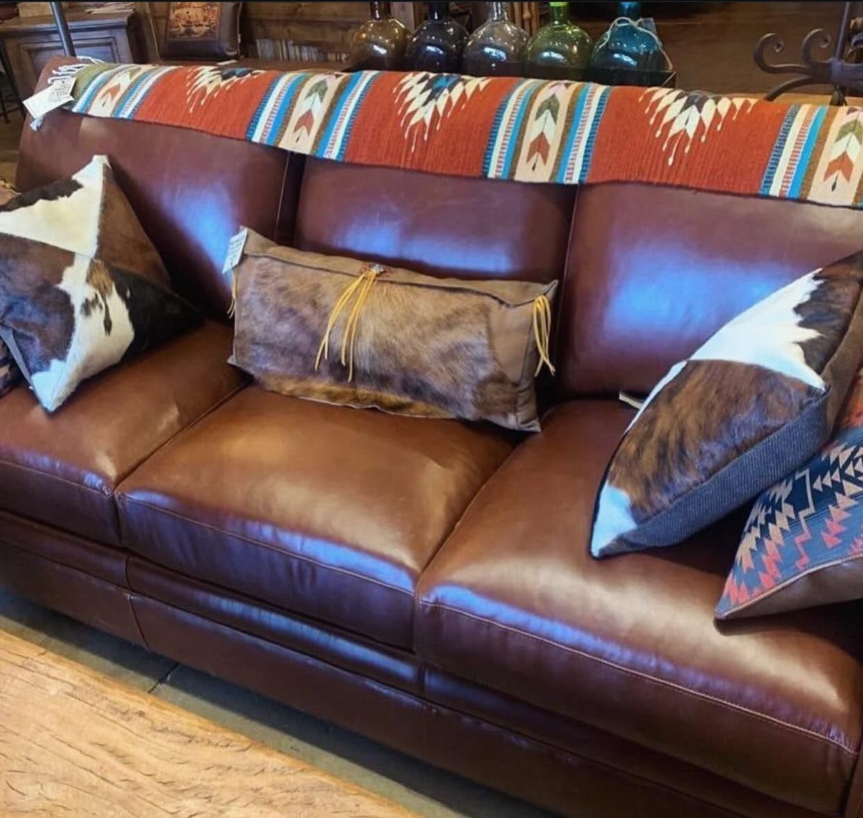 Leather couch with cow hide pillows Leather couch with cow hide throw pillows.